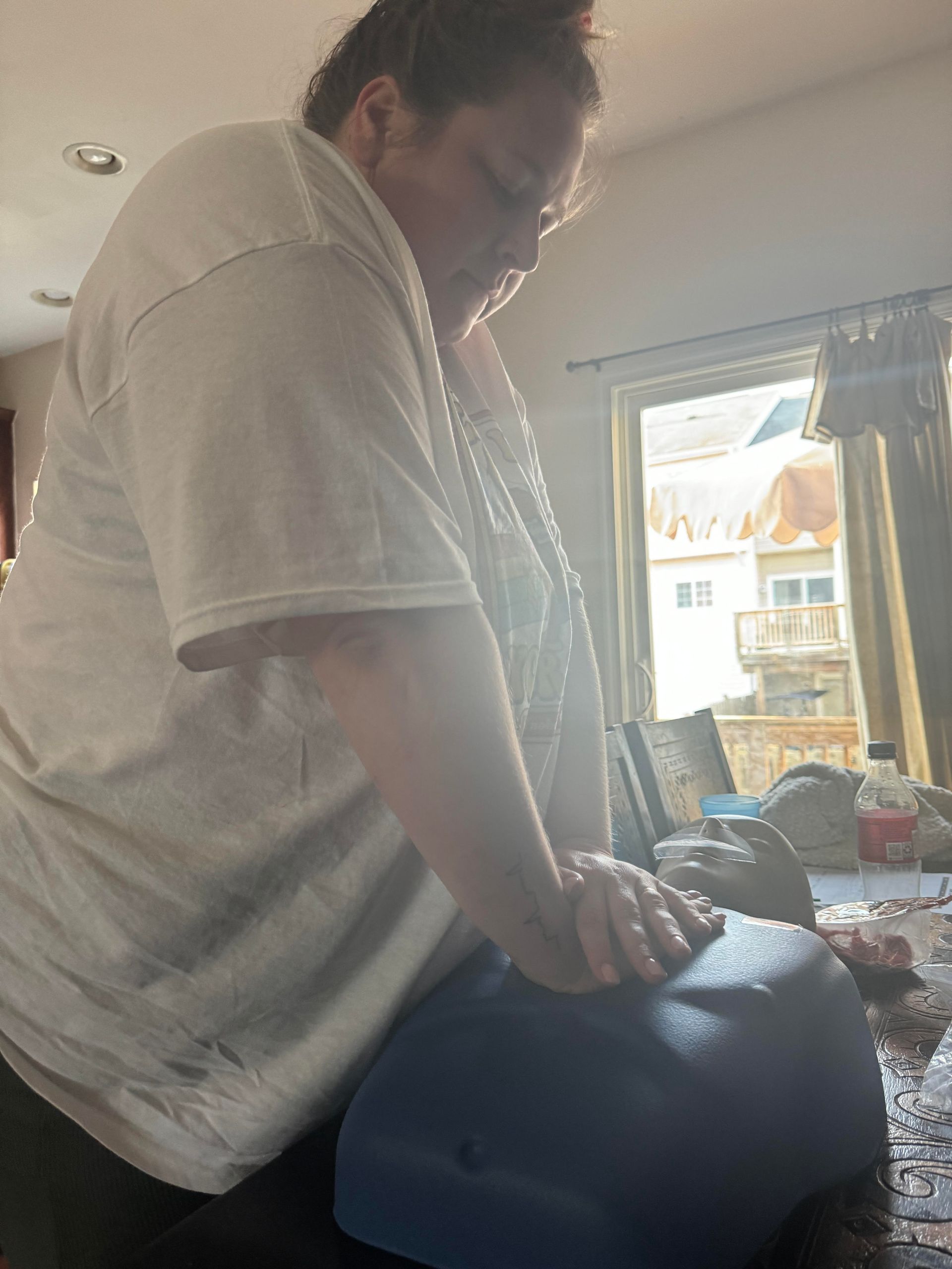 A woman is kneeling on a blue bowl in a living room.
