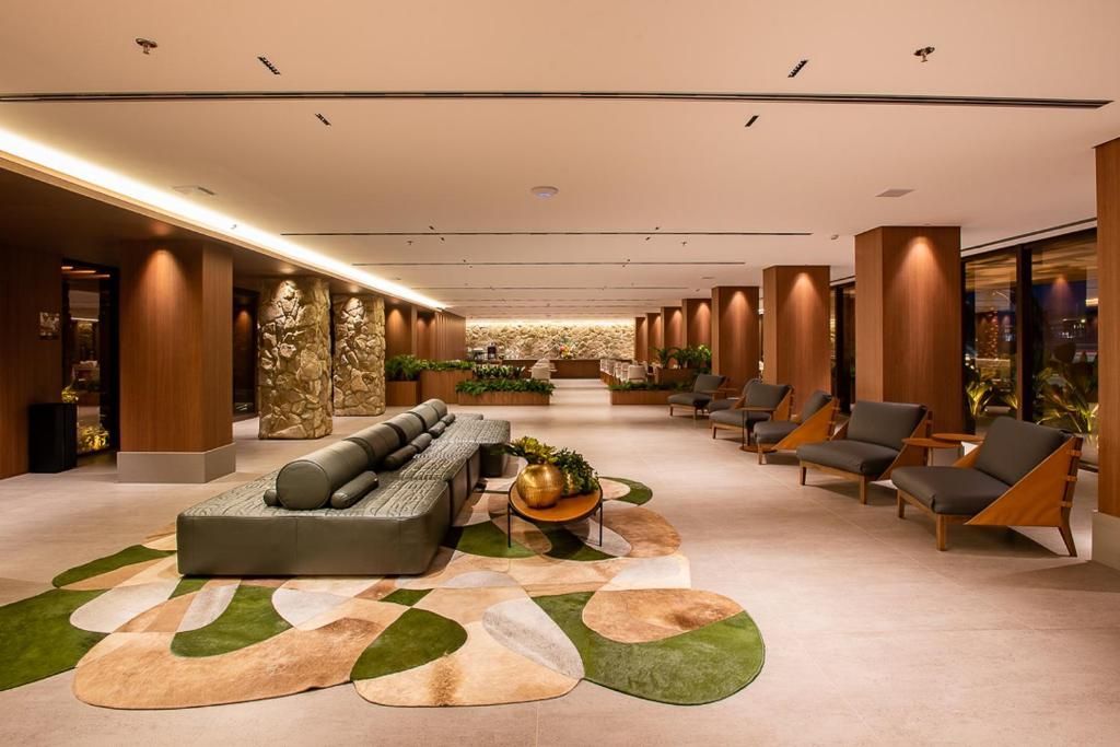 Um papagaio azul e amarelo está em pé em um galho de árvore na chuva.