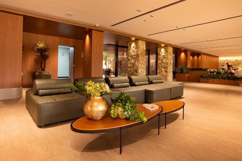 Hall de entrada com assentos modernos. Tons quentes predominam no ambiente.