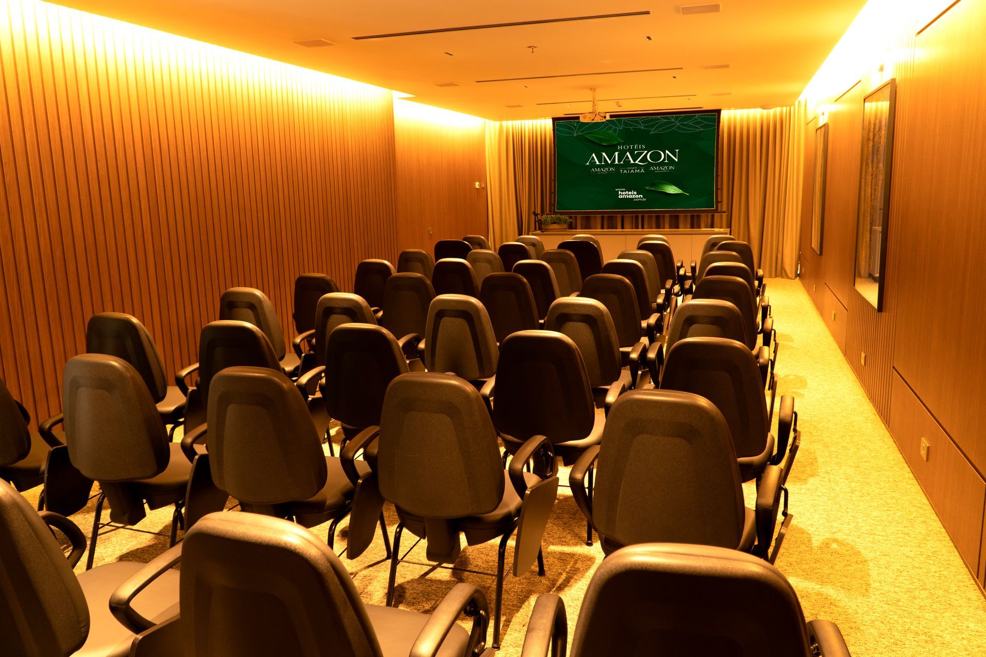 Um papagaio azul e amarelo está em pé em um galho de árvore na chuva.