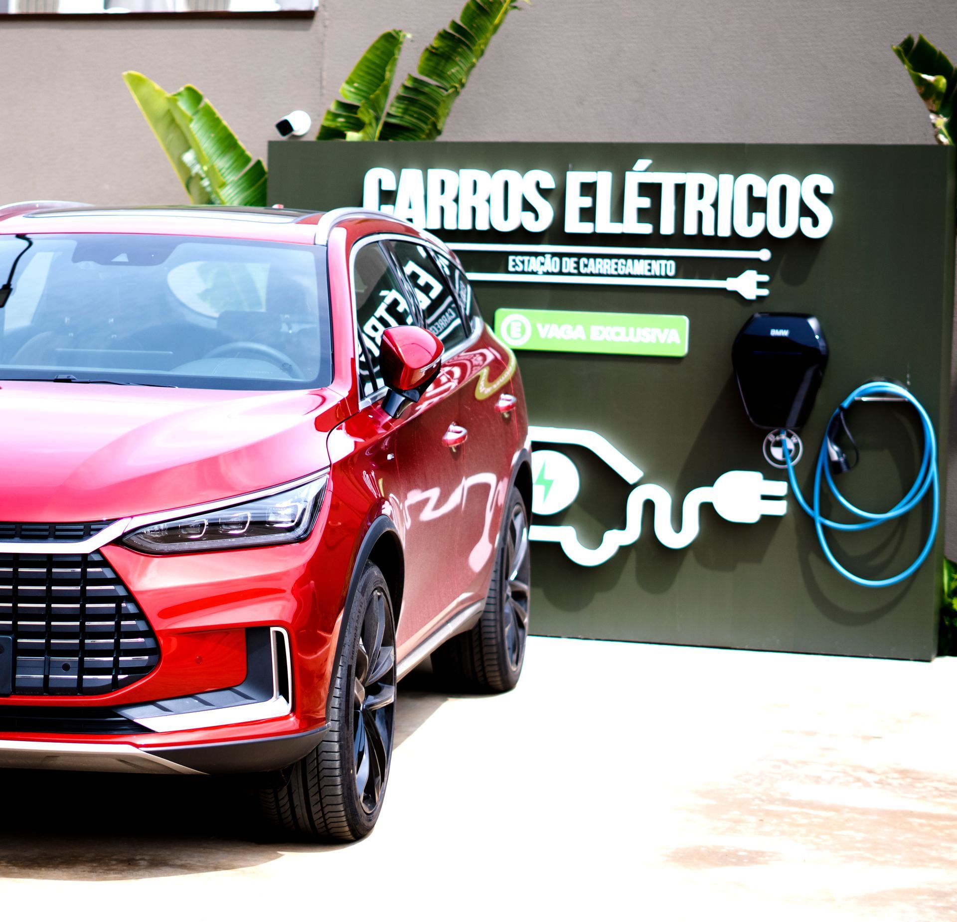 Carro elétrico estacionado perto de uma placa de estação de carregamento