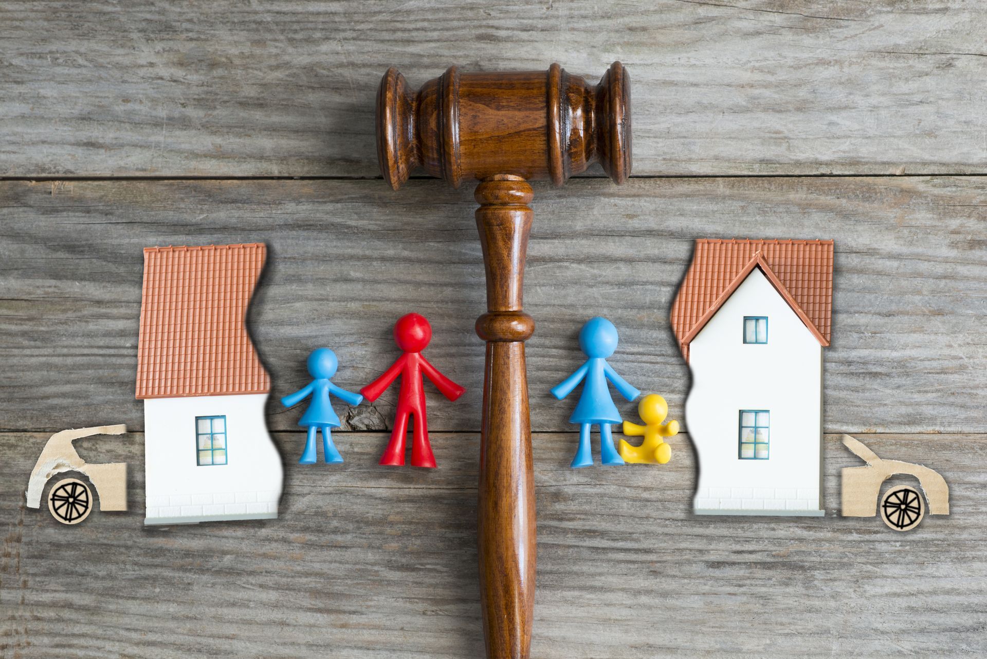 Divorce concept with a gavel dividing the family home and figures. Divorce concept with a gavel dividing the family home and figures.