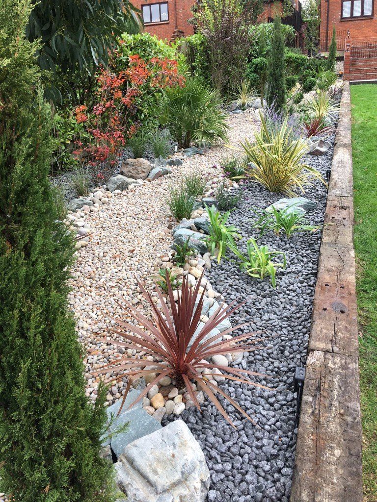 A garden filled with rocks , plants and trees.
