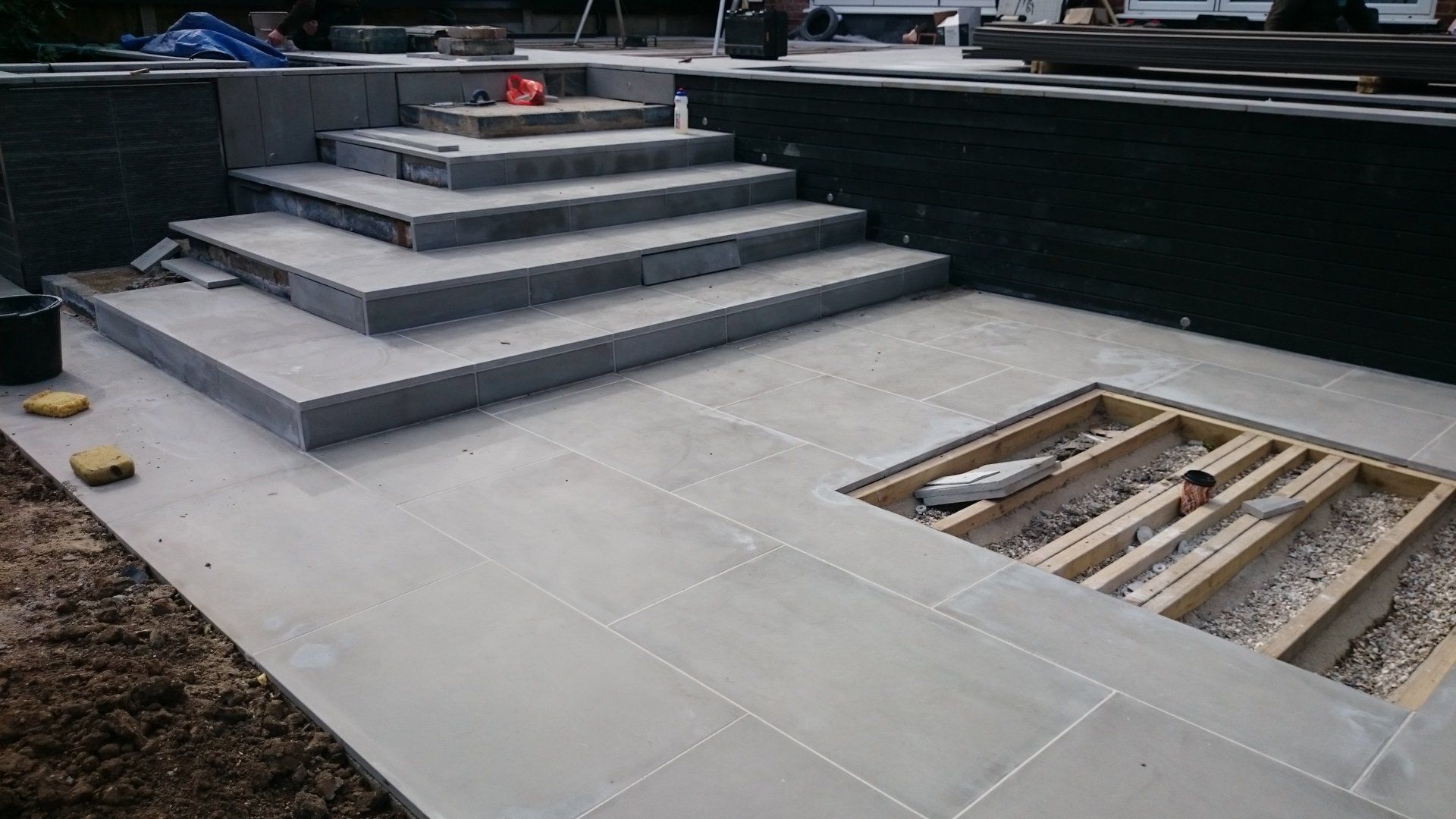 A staircase is being built into the ground next to a pool.