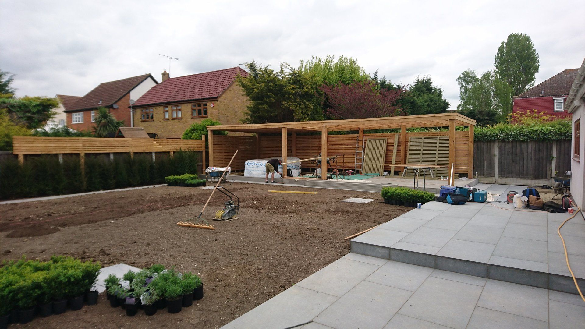 A backyard with a patio and a wooden structure in the background.
