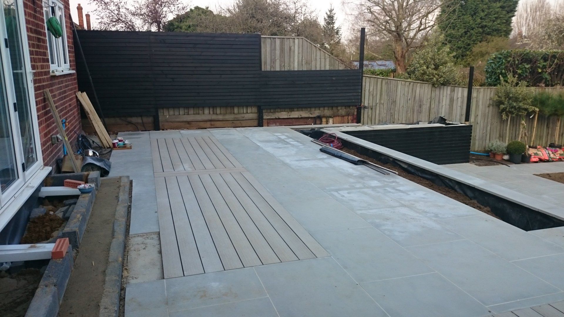 A concrete driveway is being built in front of a house.
