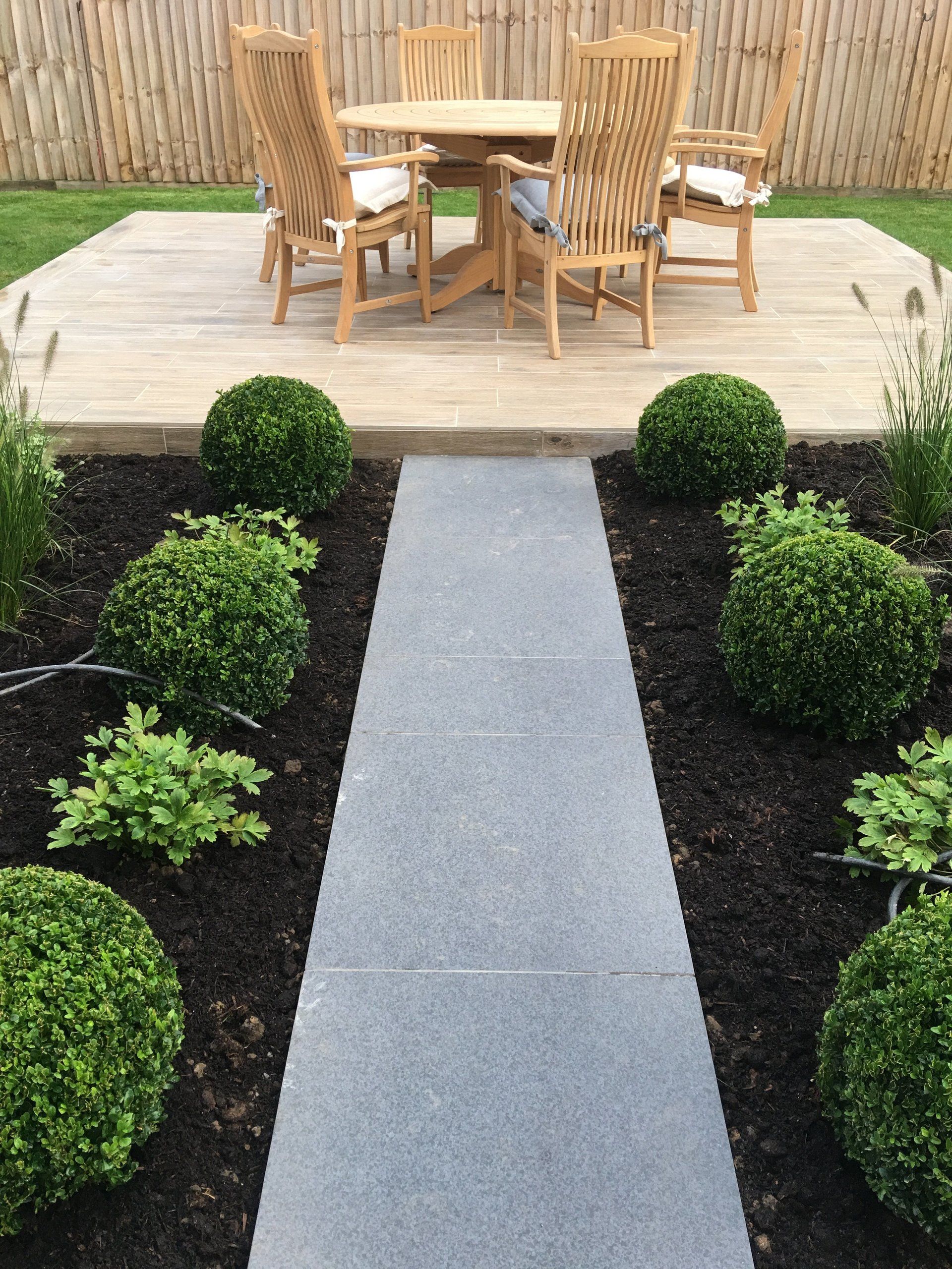 A patio with a table and chairs and a walkway