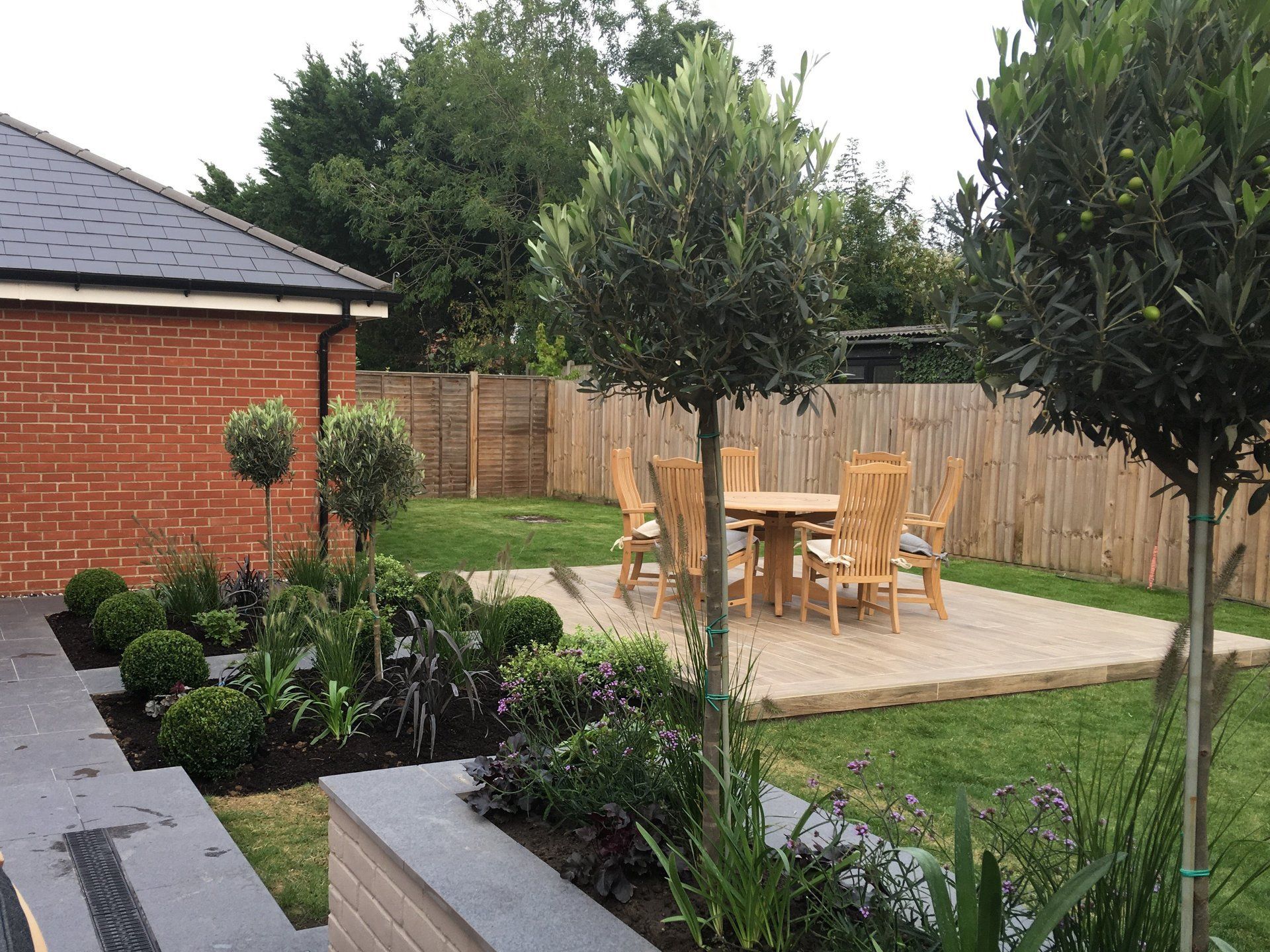 There is a table and chairs in the backyard of a house.