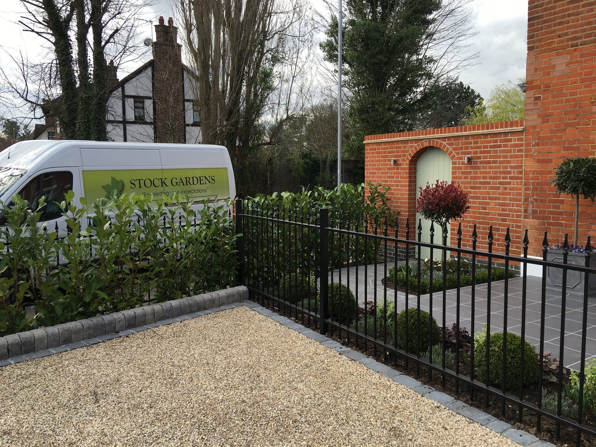 A white van is parked in front of a brick building.