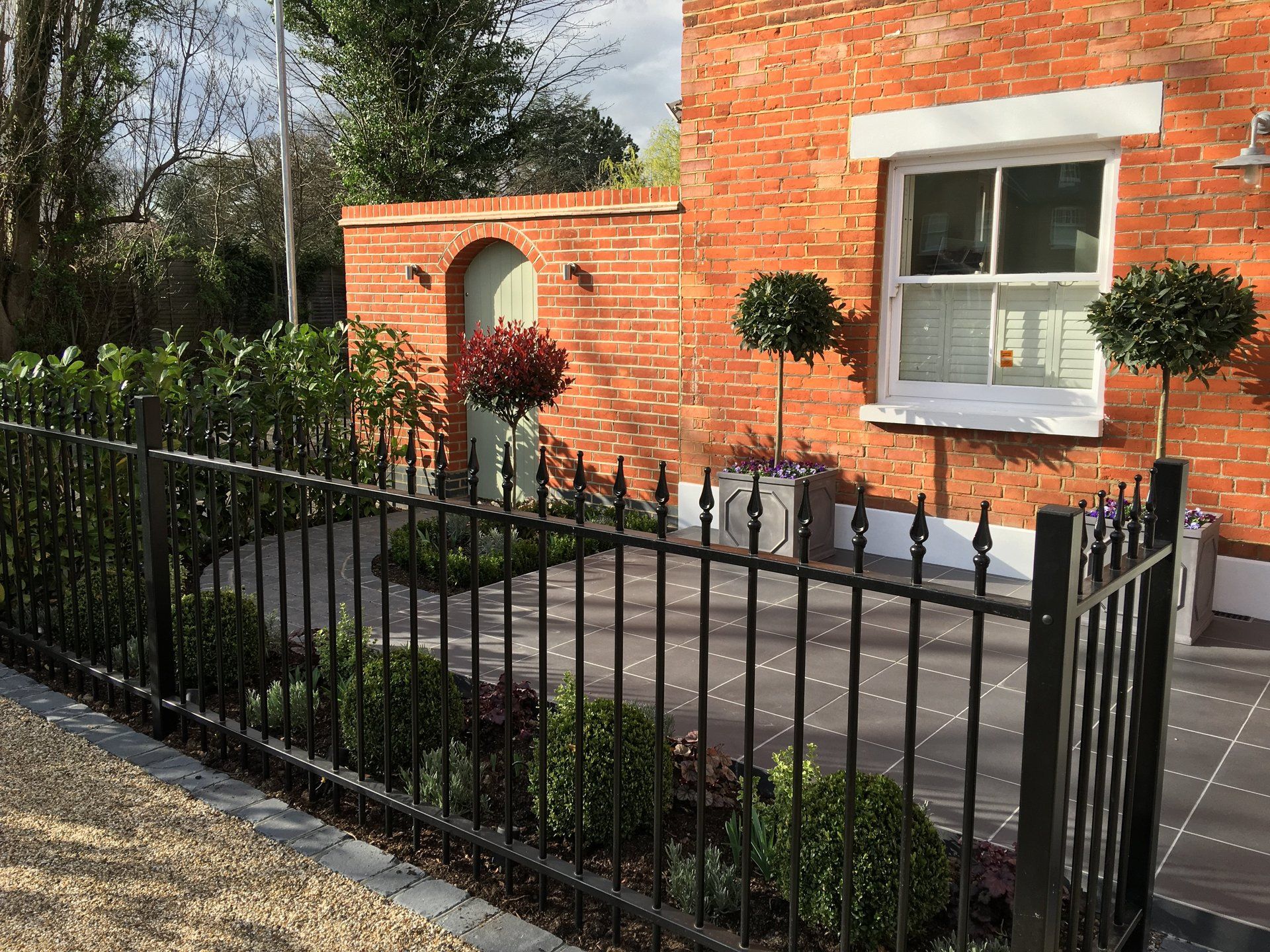 A brick house with a black fence in front of it