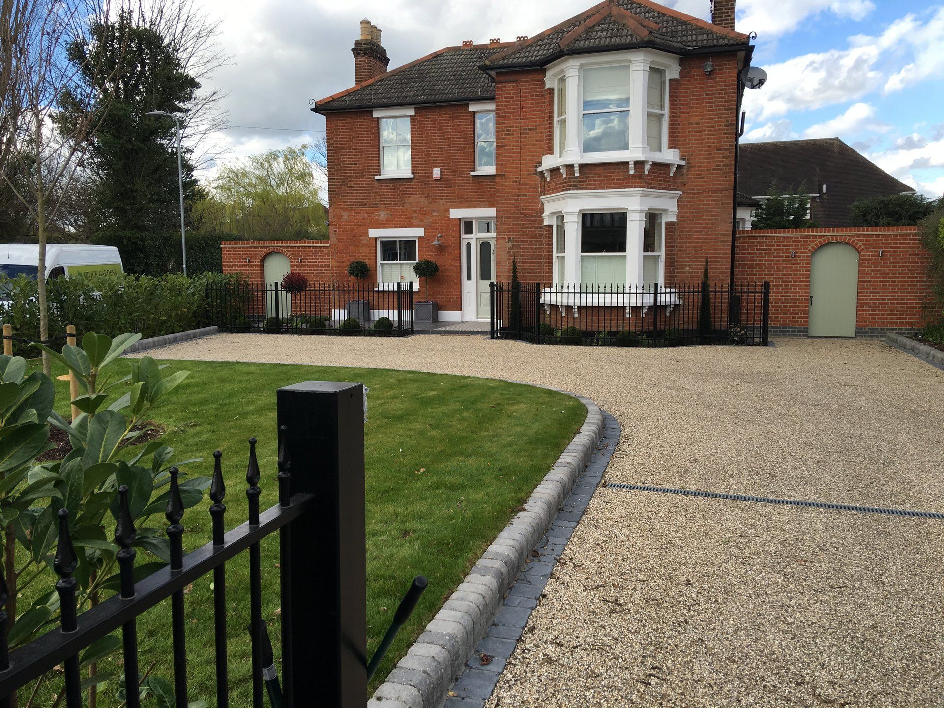 A large brick house with a gravel driveway in front of it