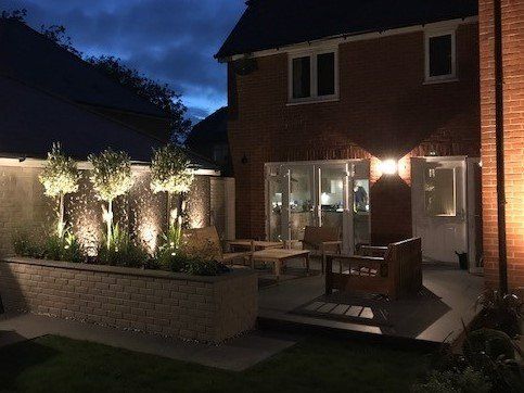The backyard of a house is lit up at night.