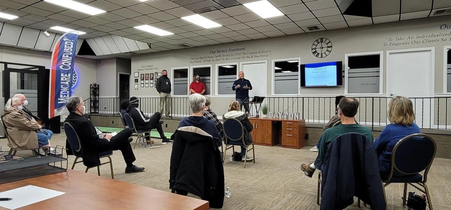 A group of people sit in chairs arranged in a circle.