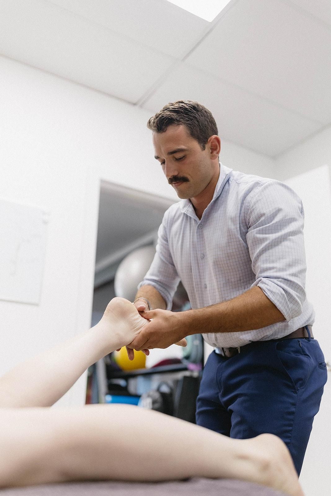 A Man is Giving a Woman a Massage on Her Foot — Biomedical Sports Podiatry in Forster, NSW