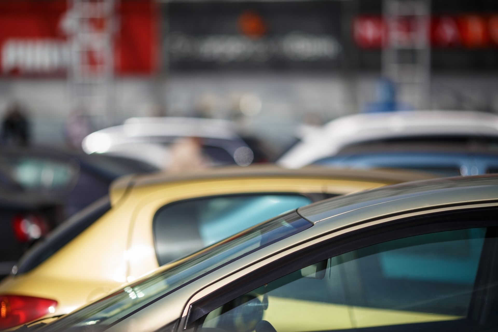 A row of cars are parked in a parking lot.