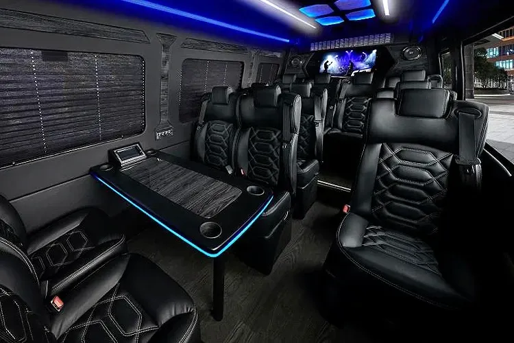 The inside of a van with black seats and a table.