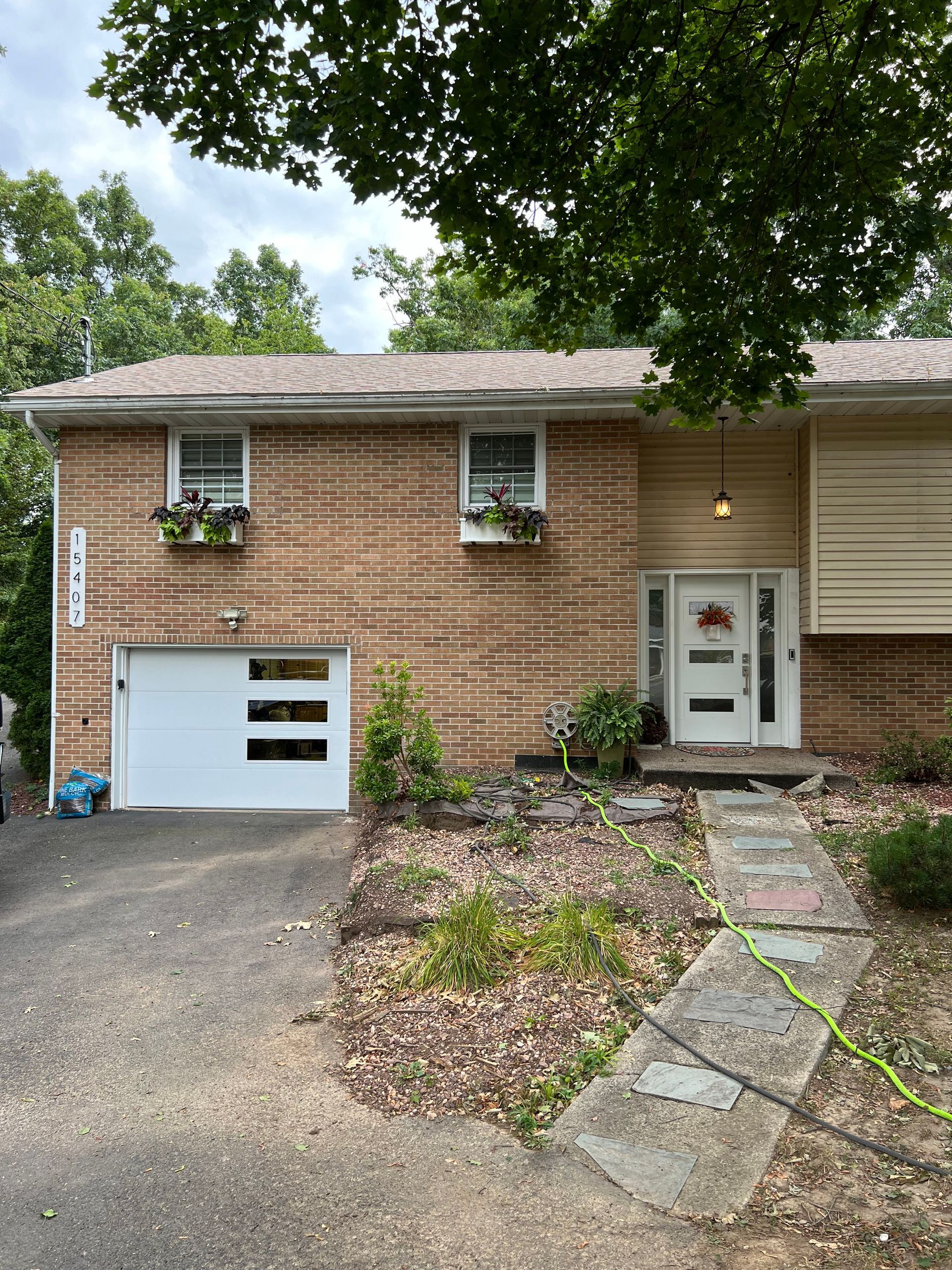 A brick house with a white garage door and a white door.