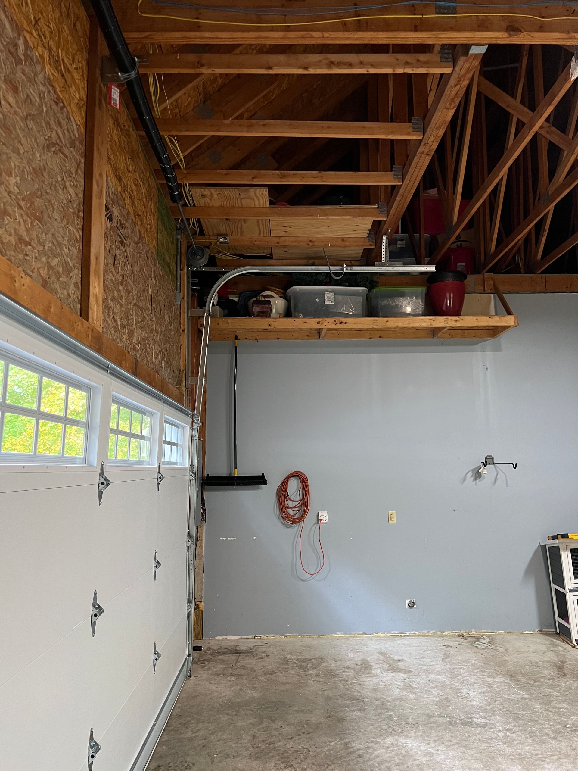 A garage with a garage door open and a wooden ceiling.