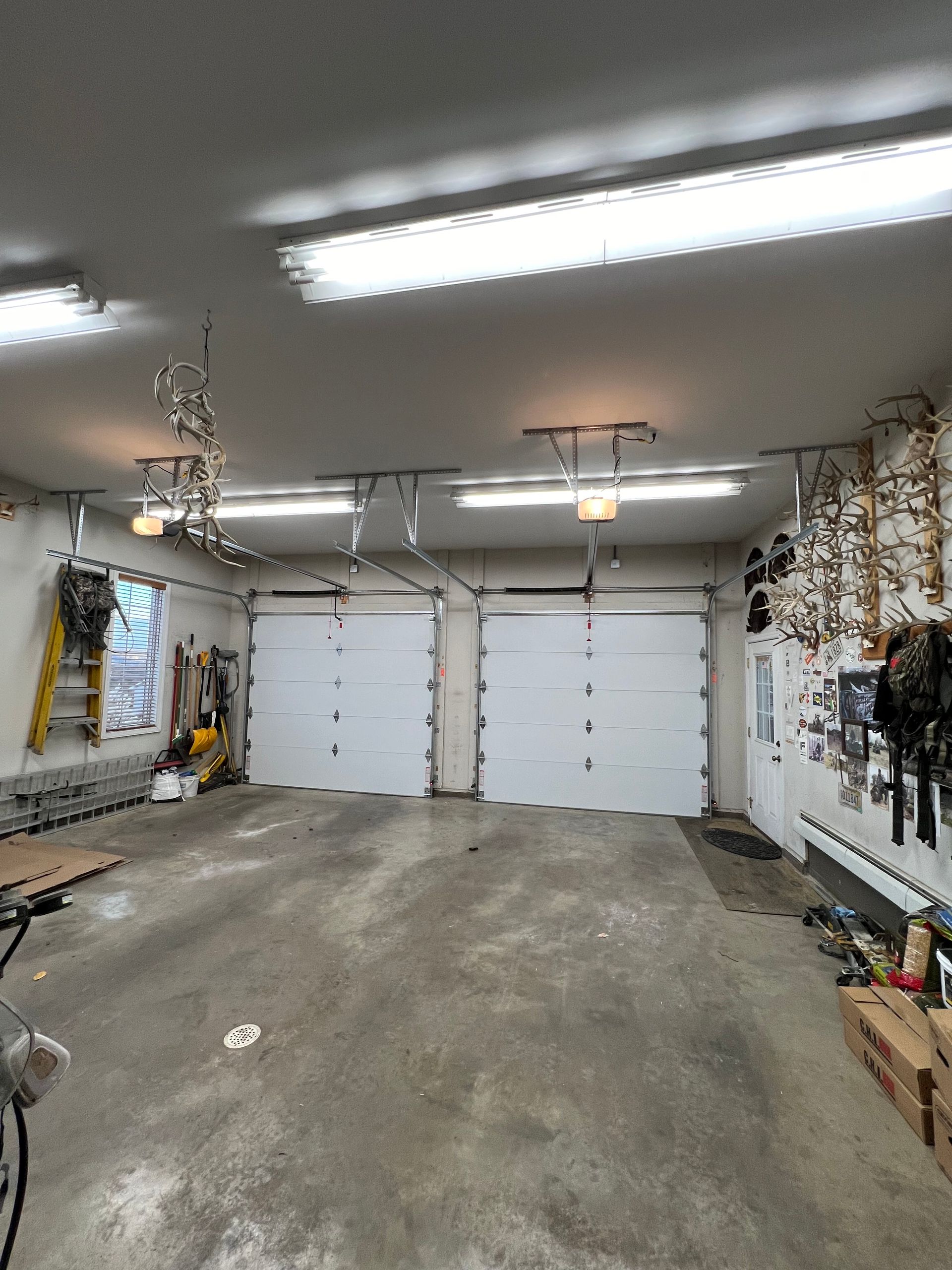 A garage with two garage doors and a bicycle in it.