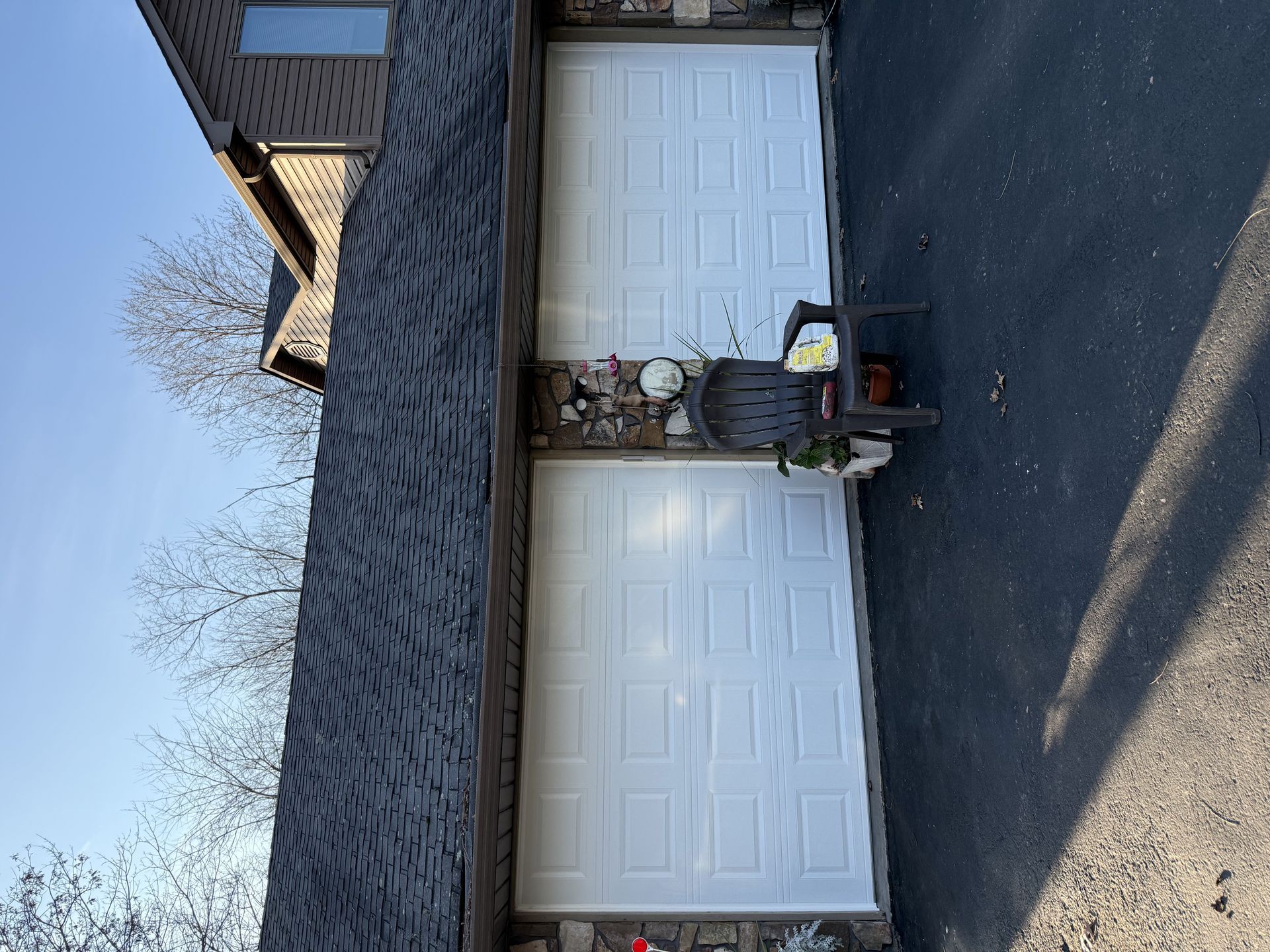 A white garage door with a chair in front of it