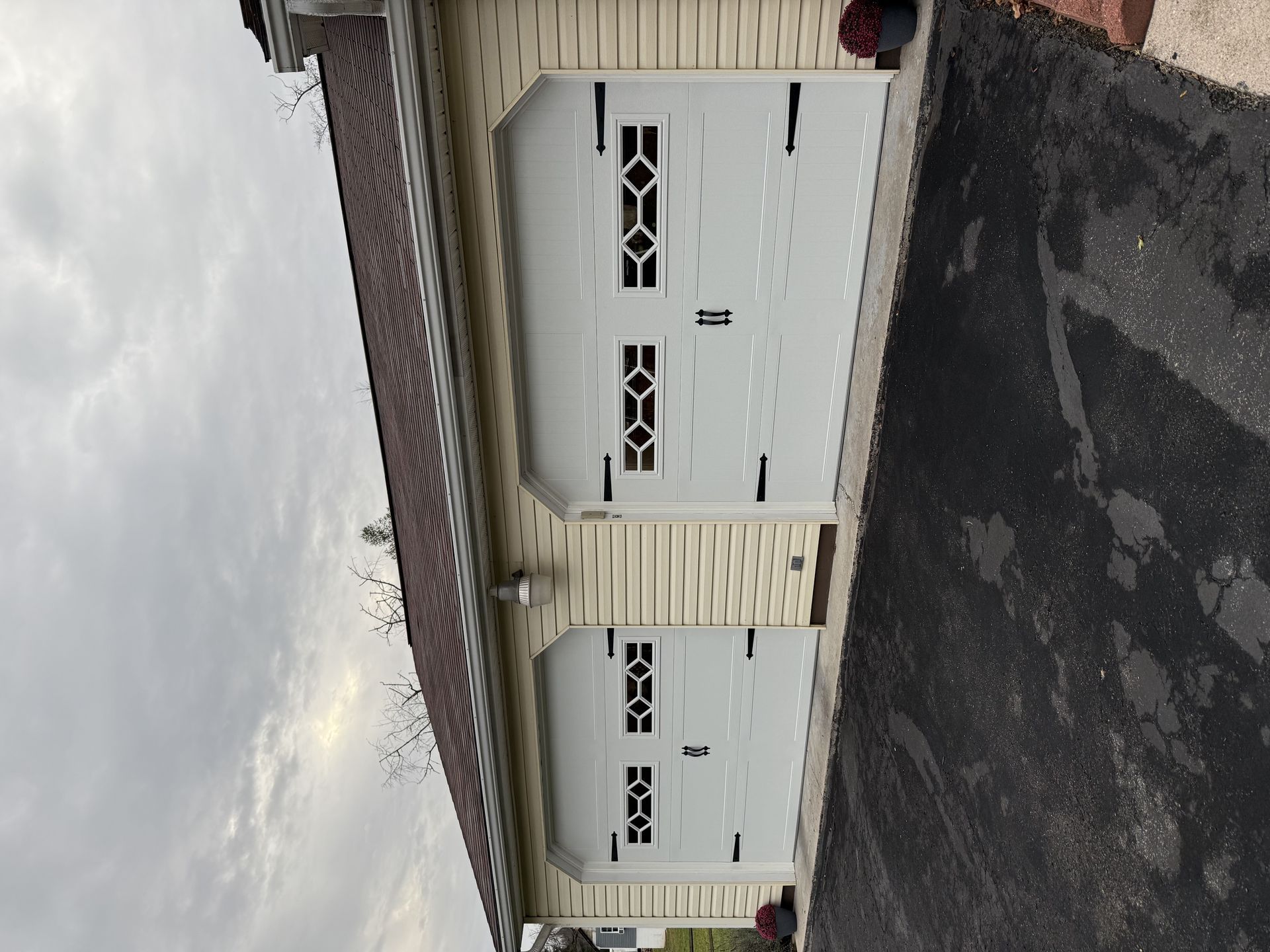 There are two garage doors on the side of a house.