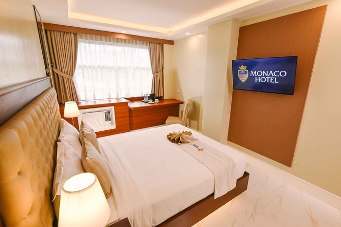 A hotel room with a large bed and a flat screen tv.