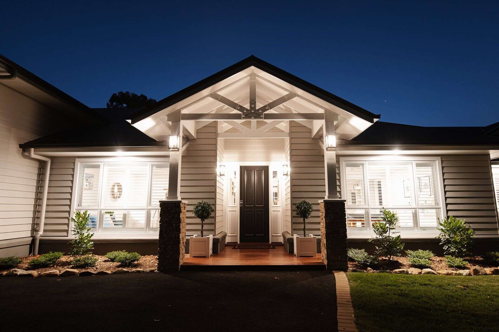 The Front of A House Is Lit up At Night — Michael Duncan Constructions Pty Ltd in Robina, QLD