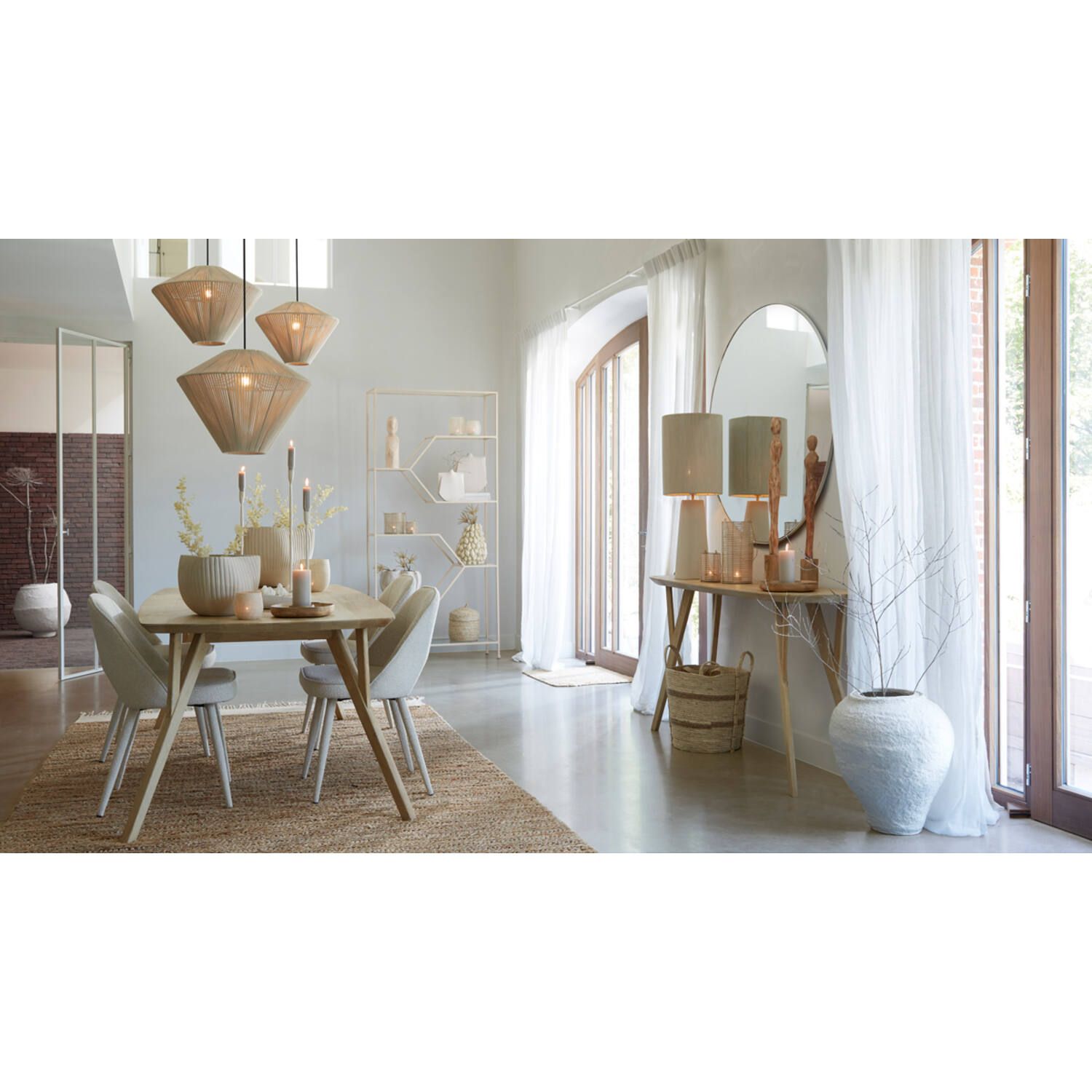 Eetkamer met houten tafel, gevlochten lampen, stoelen en decoratie.