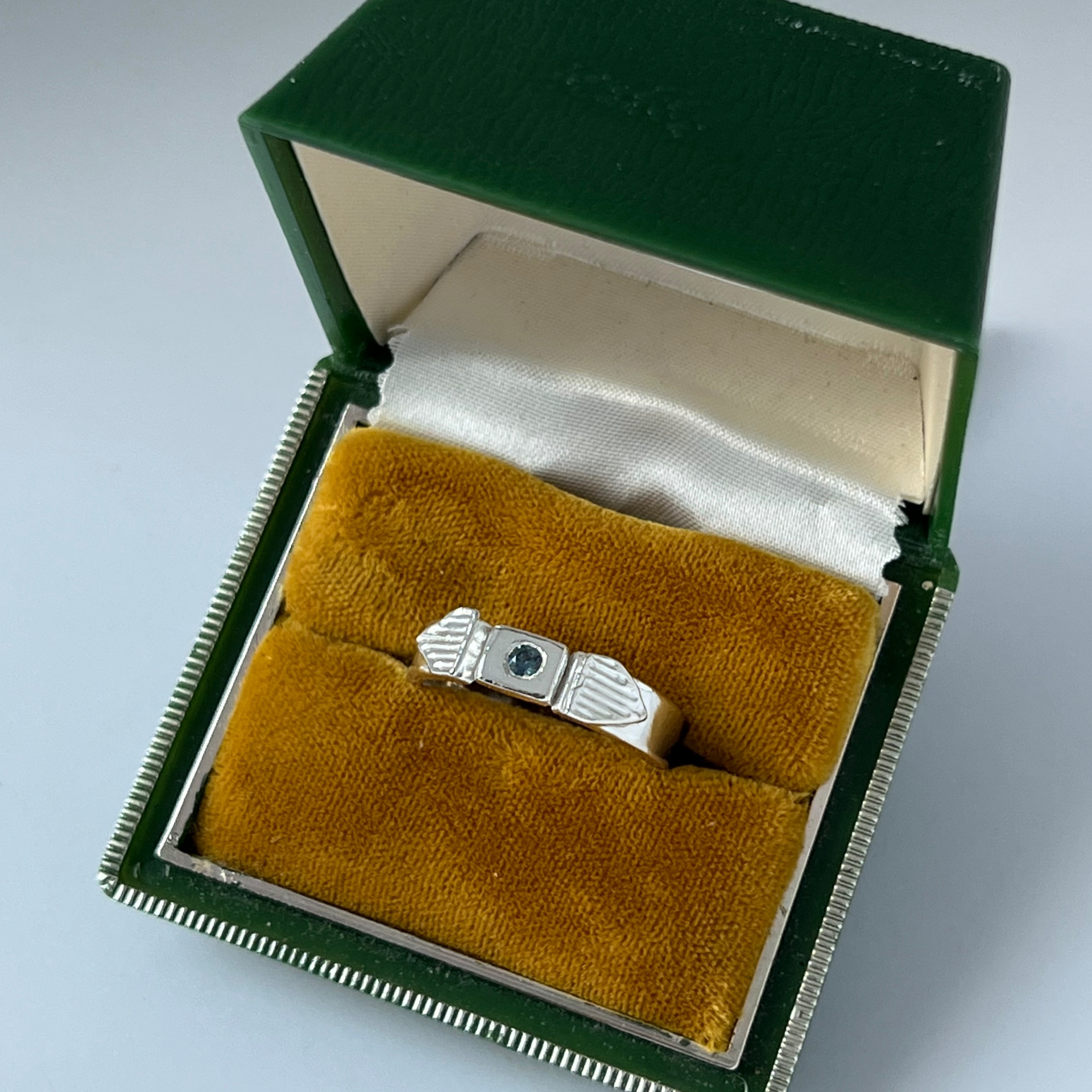 Silver ring with a raised design on a hand with pale skin. Wild Sunflower Silver Handmade Jewelry