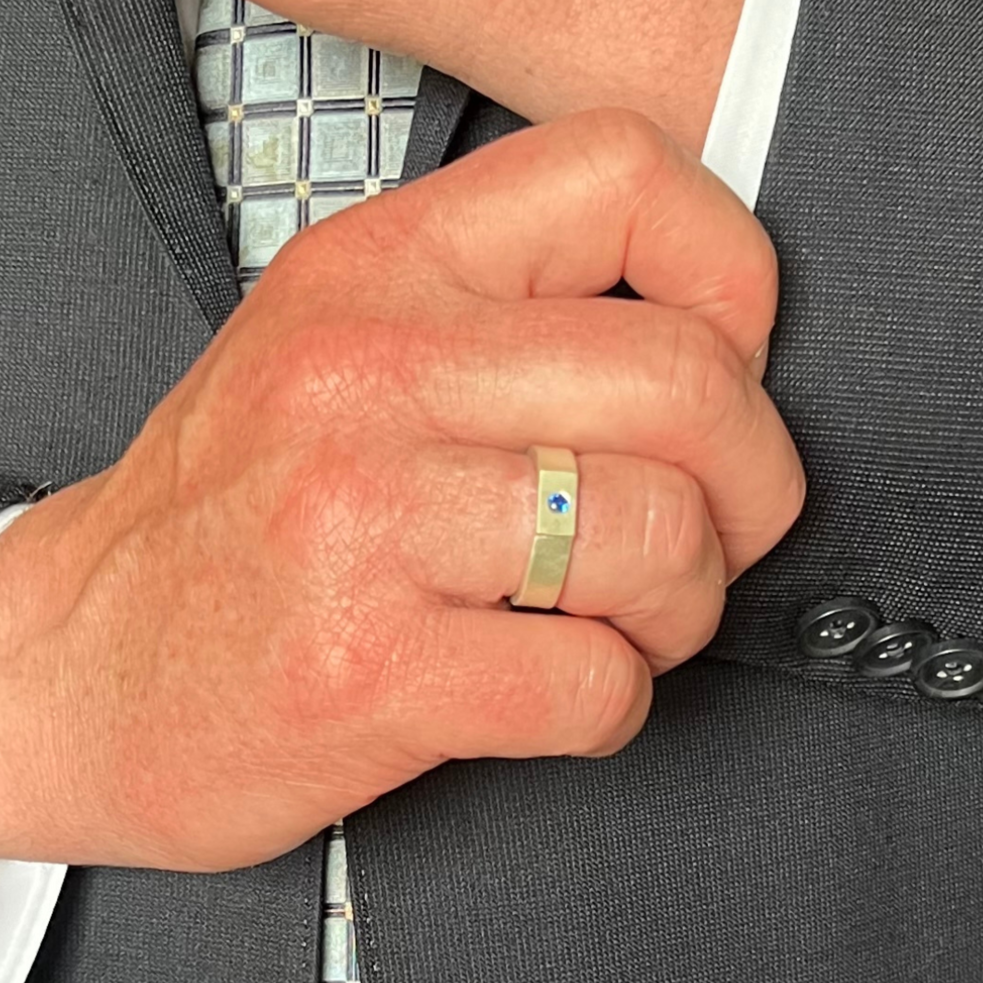 Silver ring with a square setting holding a small blue stone. Wild Sunflower Silver Handmade Jewelry