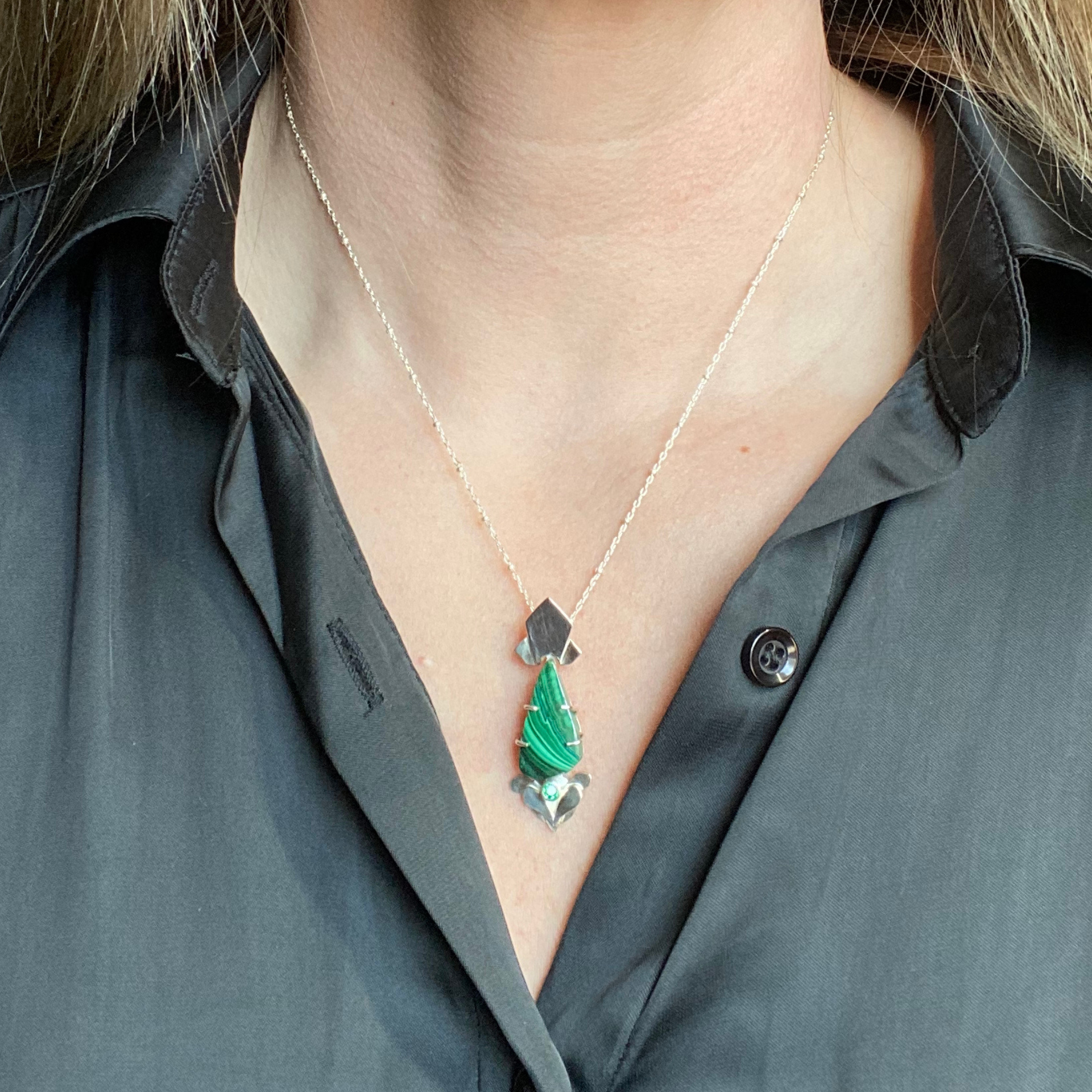 Malachite gemstone pendant with silver accents, hanging from a silver chain. Wild Sunflower Silver Handmade Jewelry