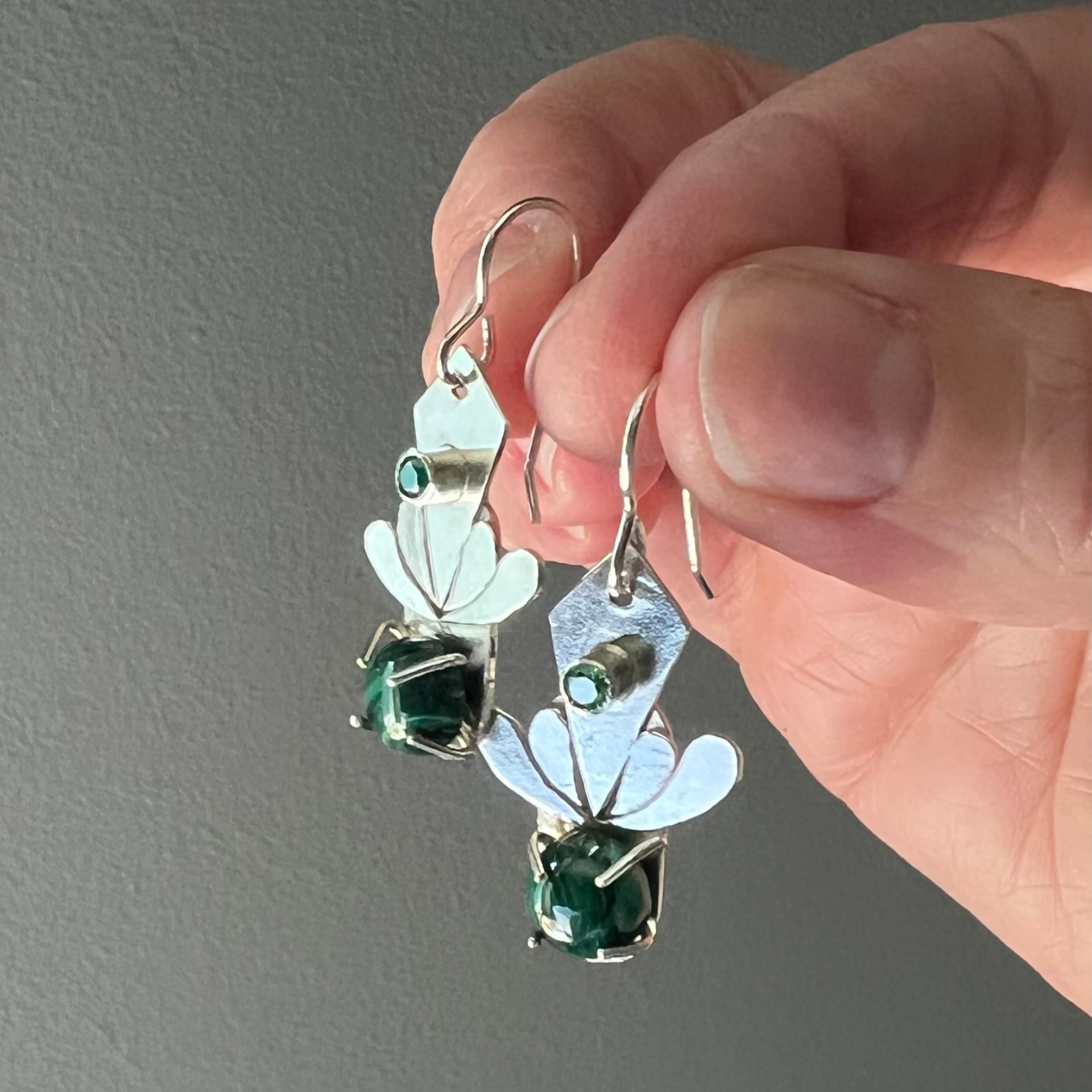 silver earring with a green stone and flower-like design. Wild Sunflower Silver Handmade Jewelry