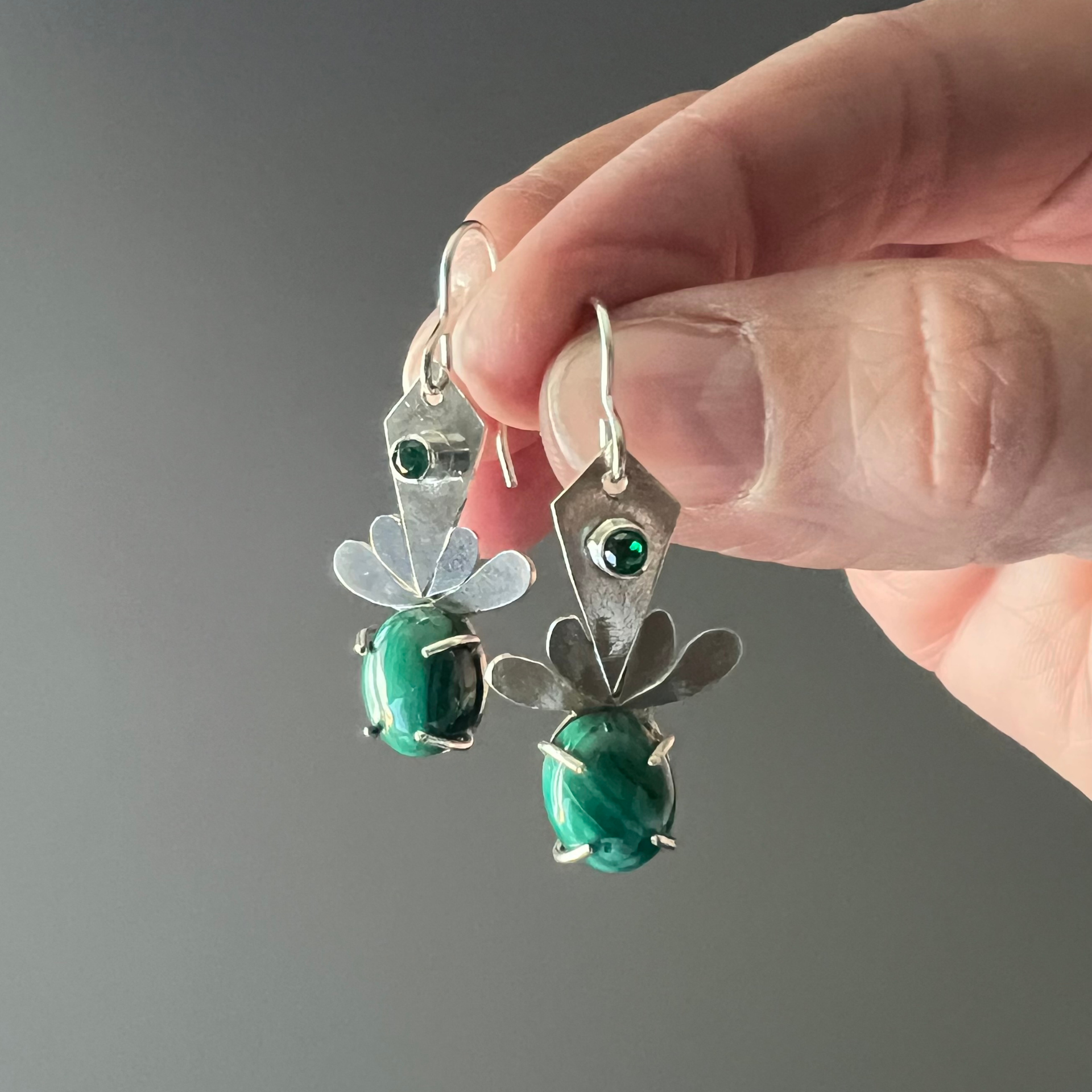 Woman's ear with a silver earring, featuring a green gemstone Wild Sunflower Silver Handmade Jewelry