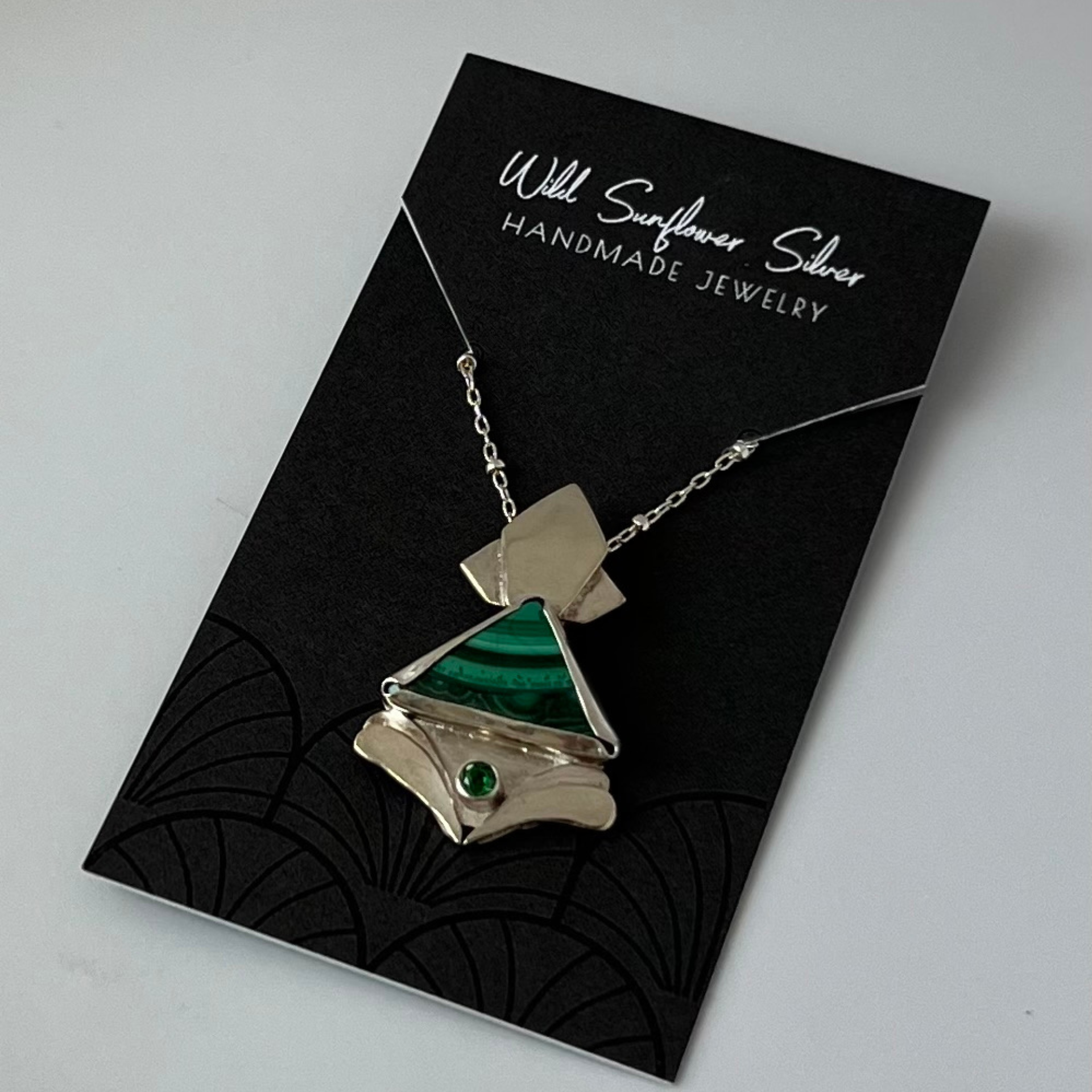 Silver necklace with a malachite pendant, displayed on a black card,Wild Sunflower Silver Handmade Jewelry