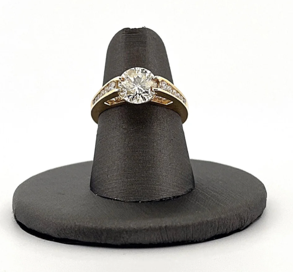 A diamond ring is sitting on a black ring holder