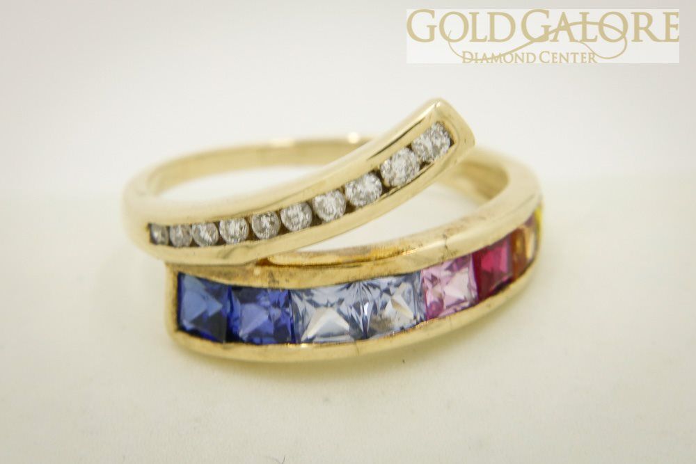 A gold ring with rainbow colored stones and diamonds