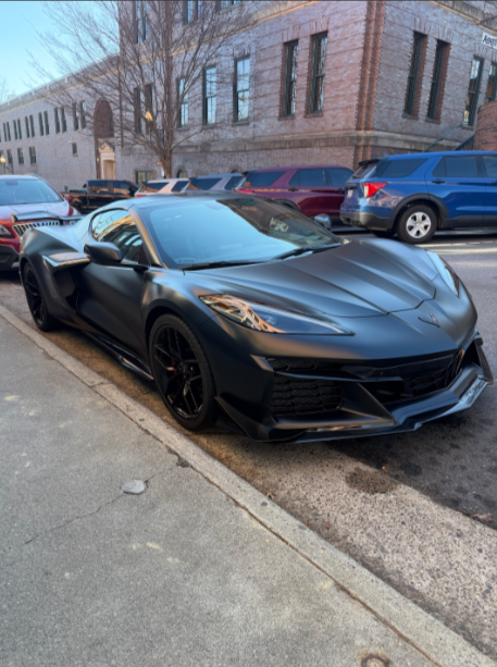 Spray bottles and car in a wet, shiny garage.