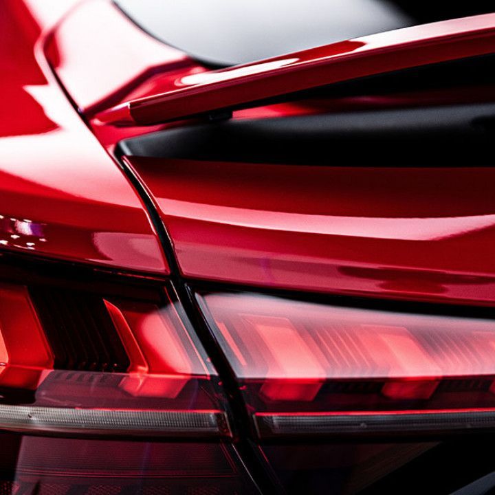 Red sports car rear detail with spoiler and taillight.