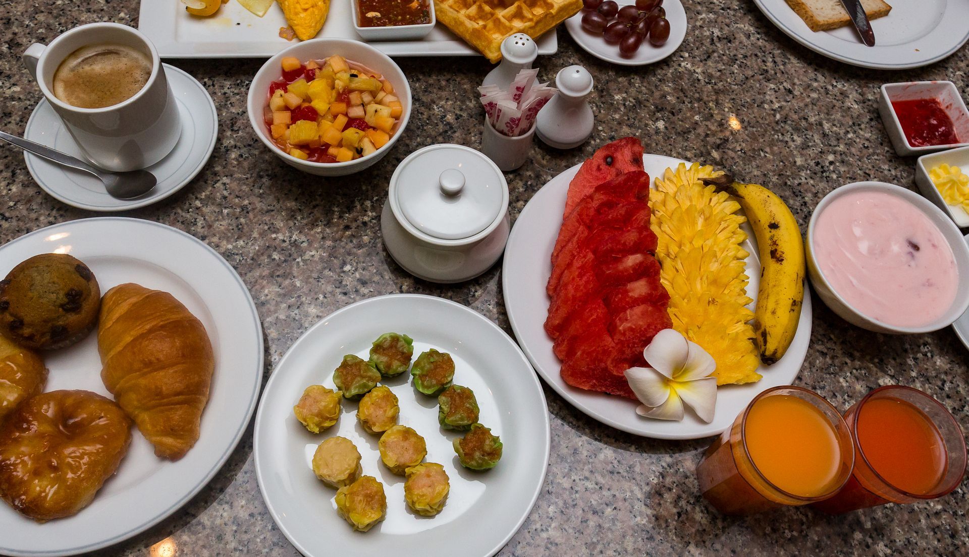 A table topped with plates of food and drinks.