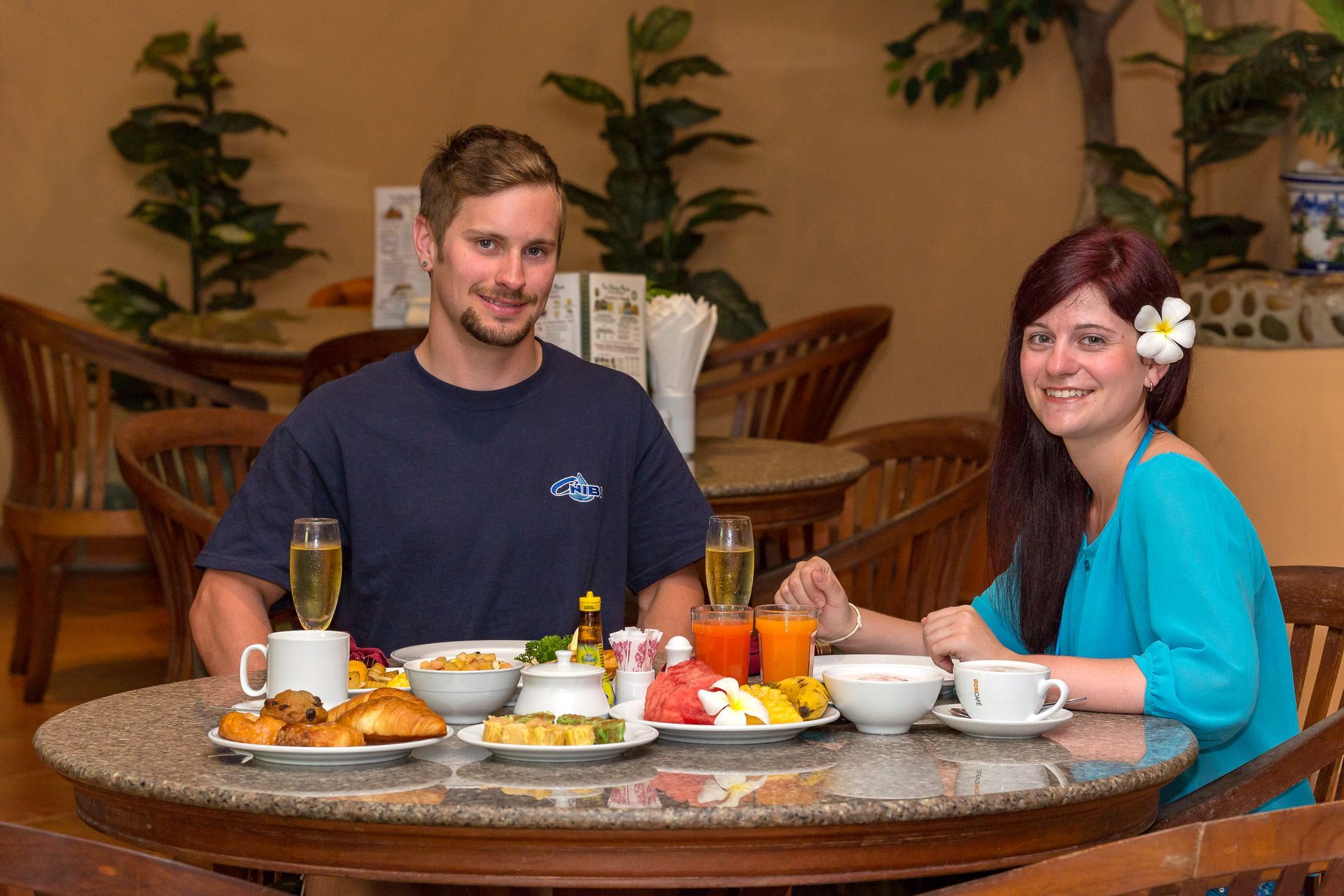 A man and a woman are sitting at a table with plates of food.