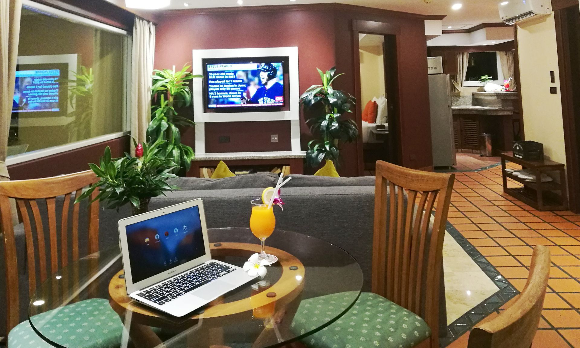A laptop is sitting on a glass table in a living room.