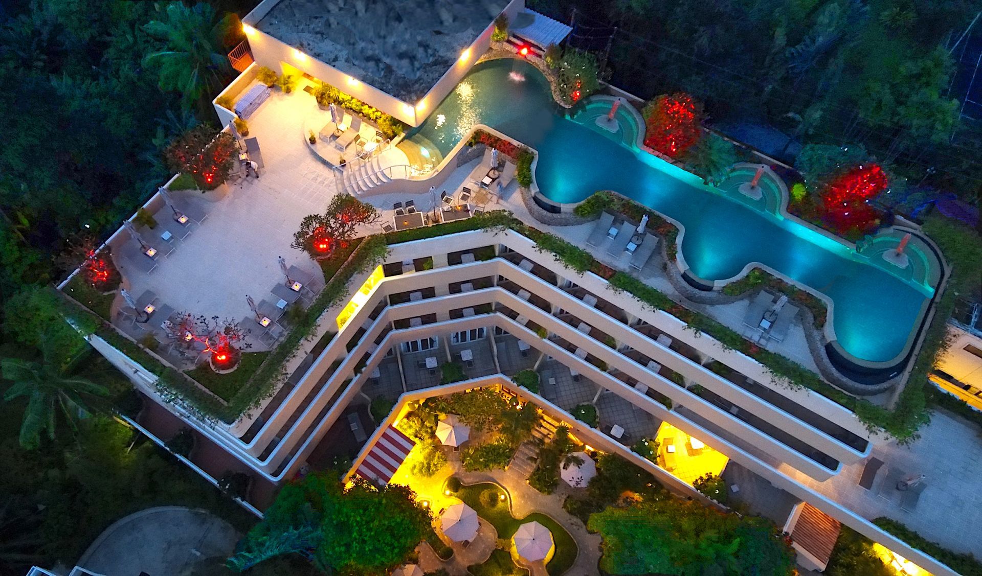 An aerial view of a hotel with a large swimming pool