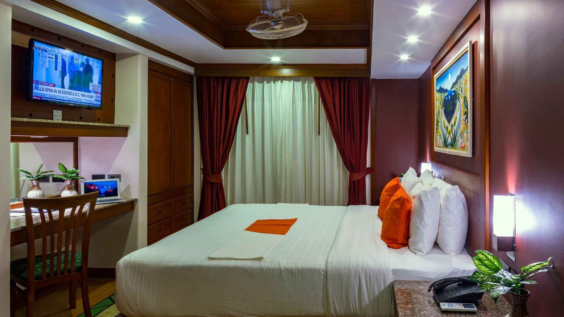 A hotel room with a large bed , desk , chair and television.