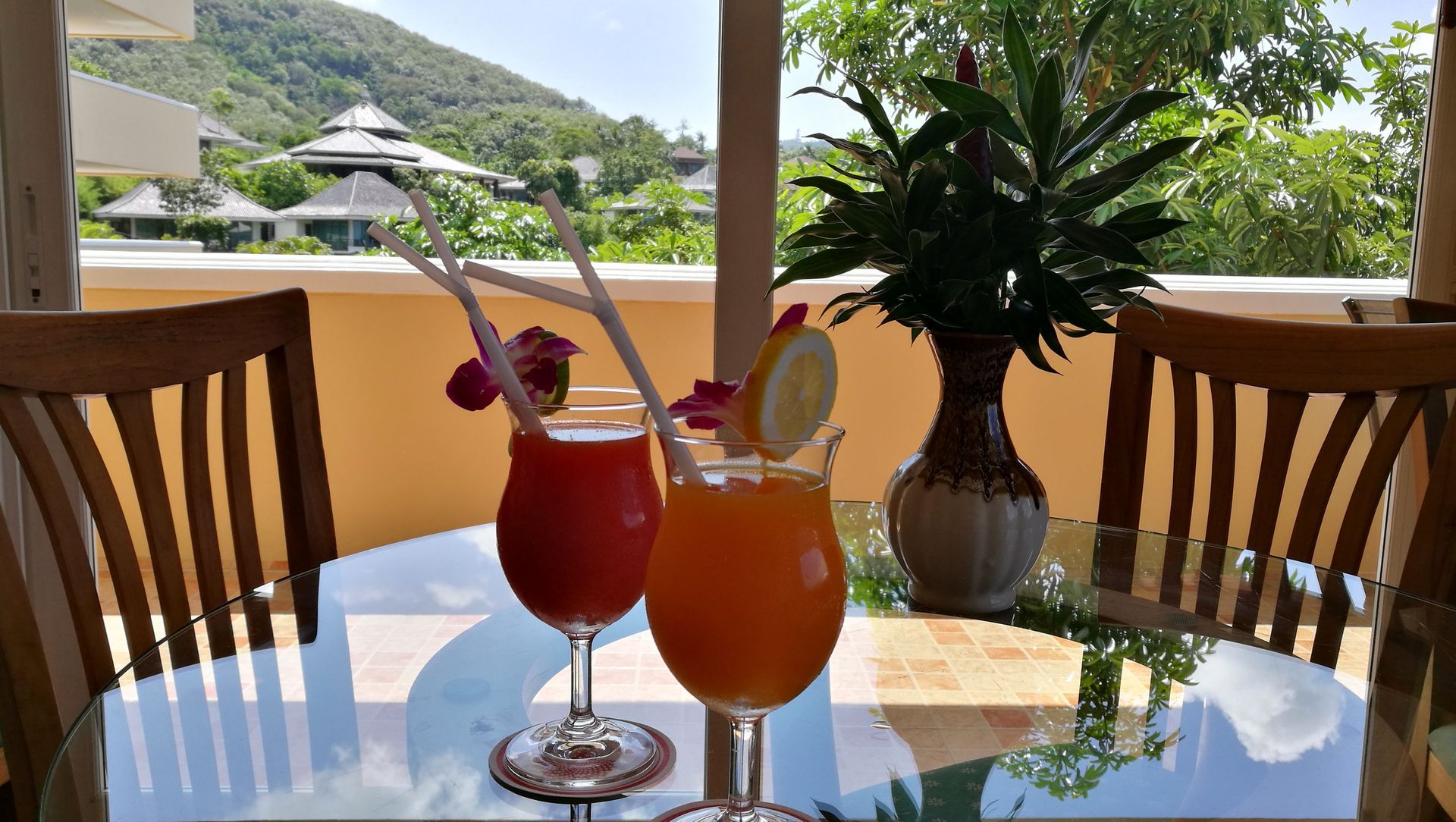 Two drinks are sitting on a table in front of a window.