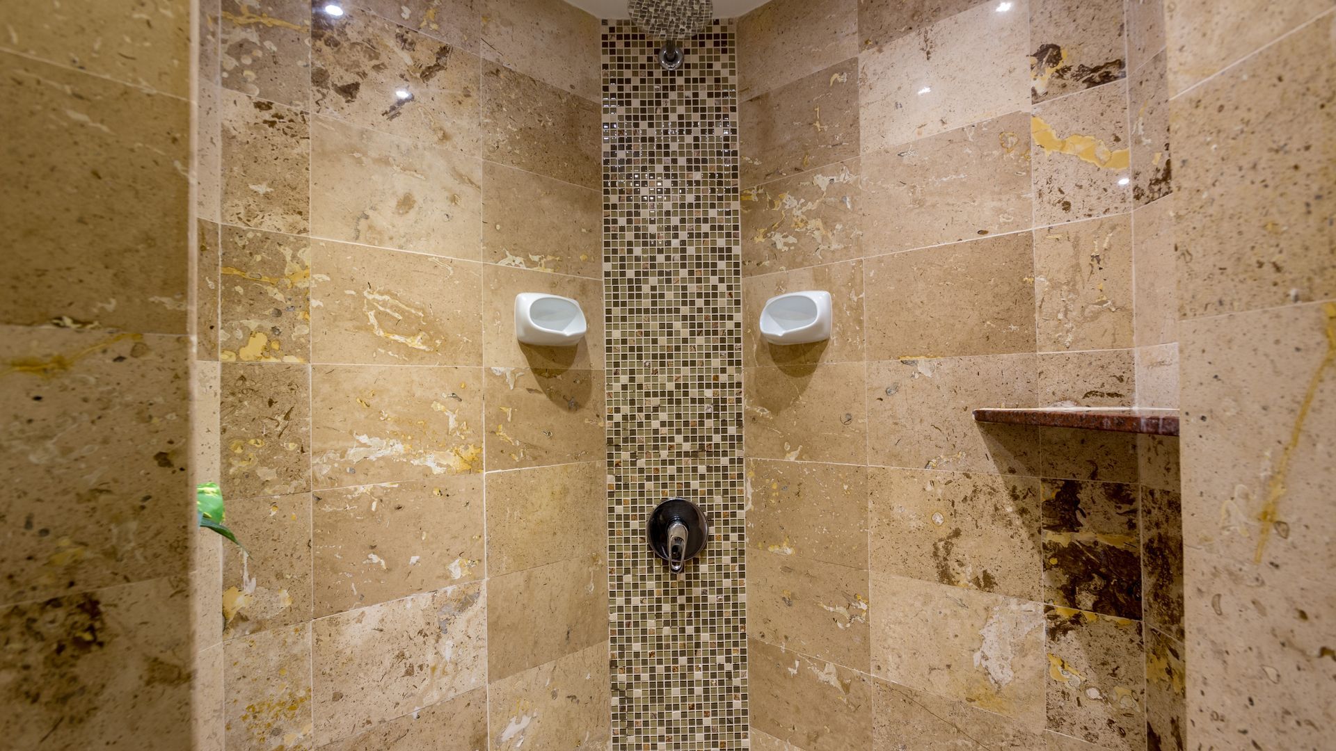 A hotel room with a large bed and orange pillows