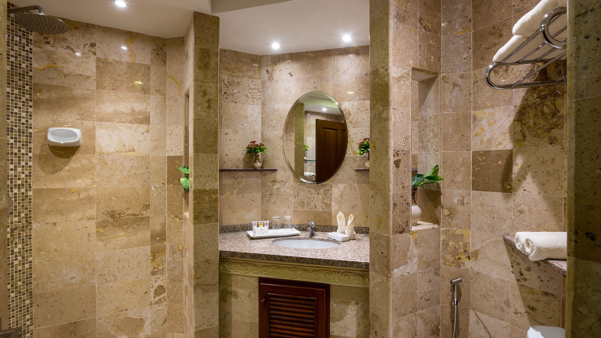 A bathroom with a sink , toilet , shower and mirror.