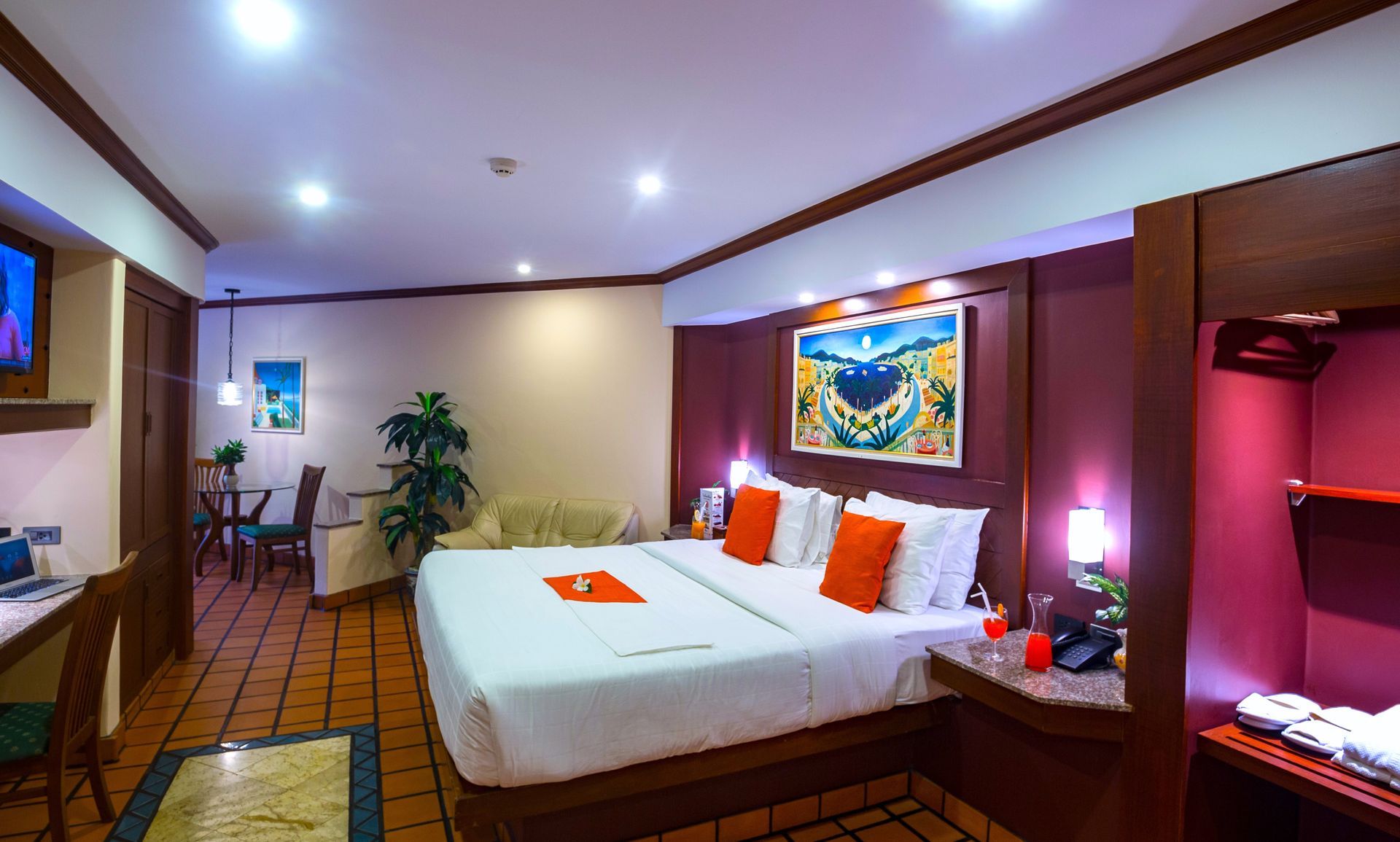 A hotel room with a large bed and a painting on the wall