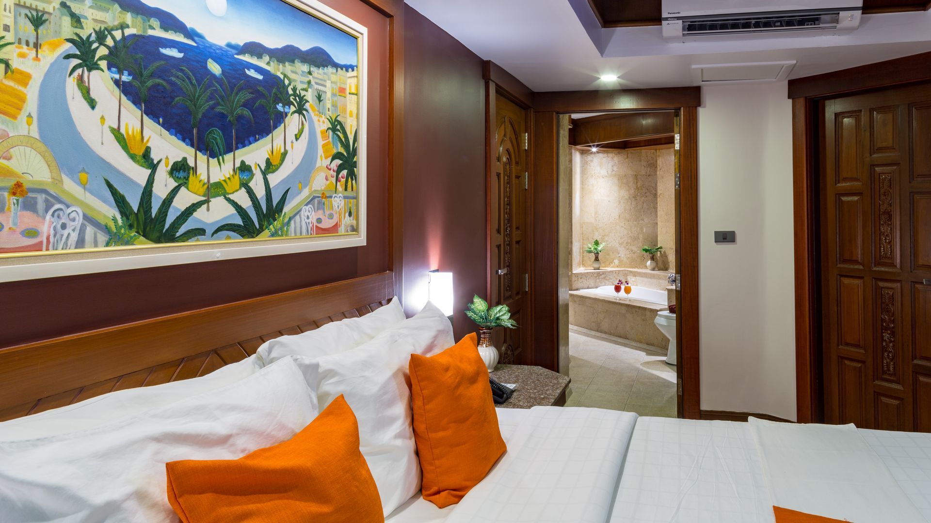 A hotel room with a bed and a painting on the wall.
