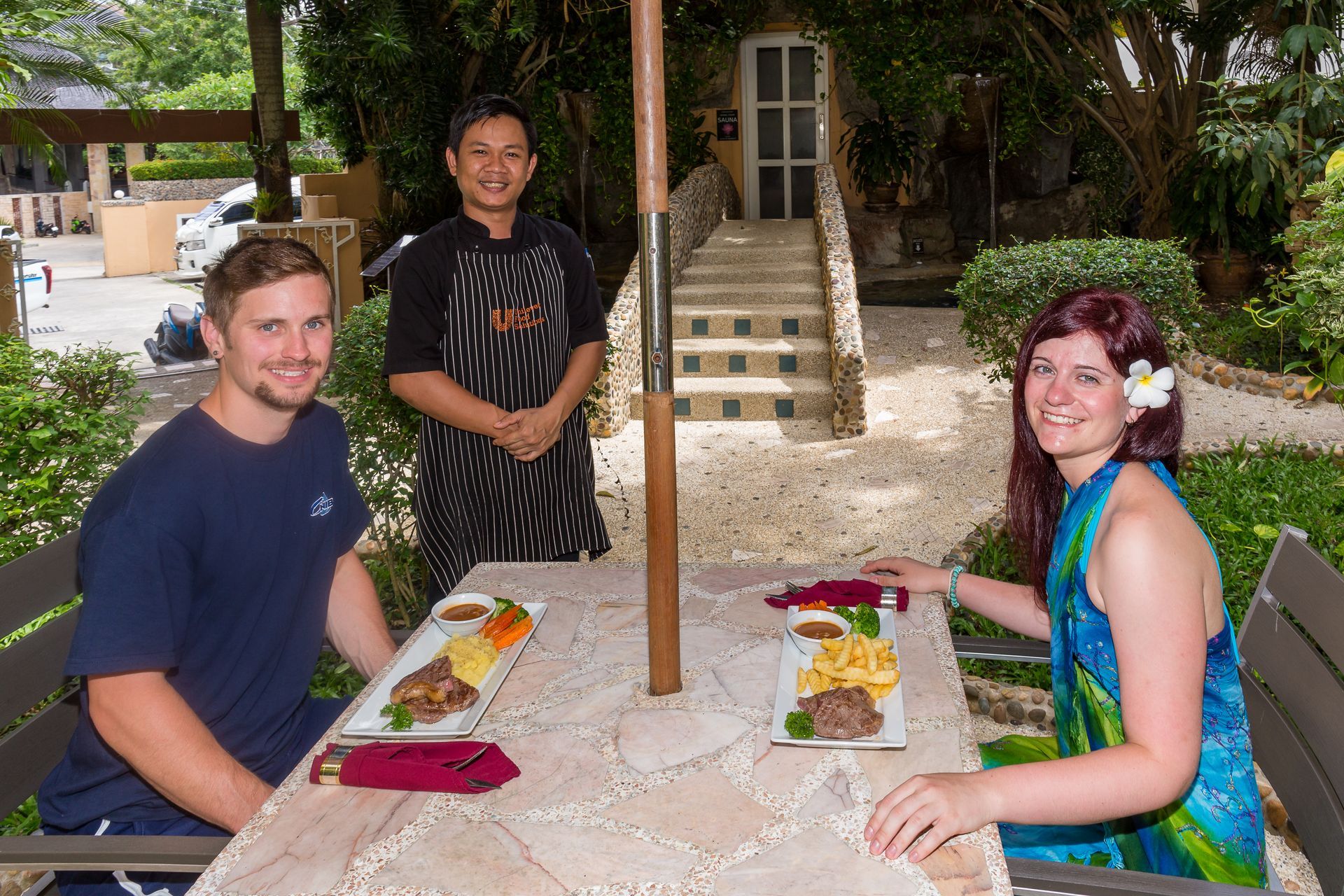A man and a woman are sitting at a table with plates of food.