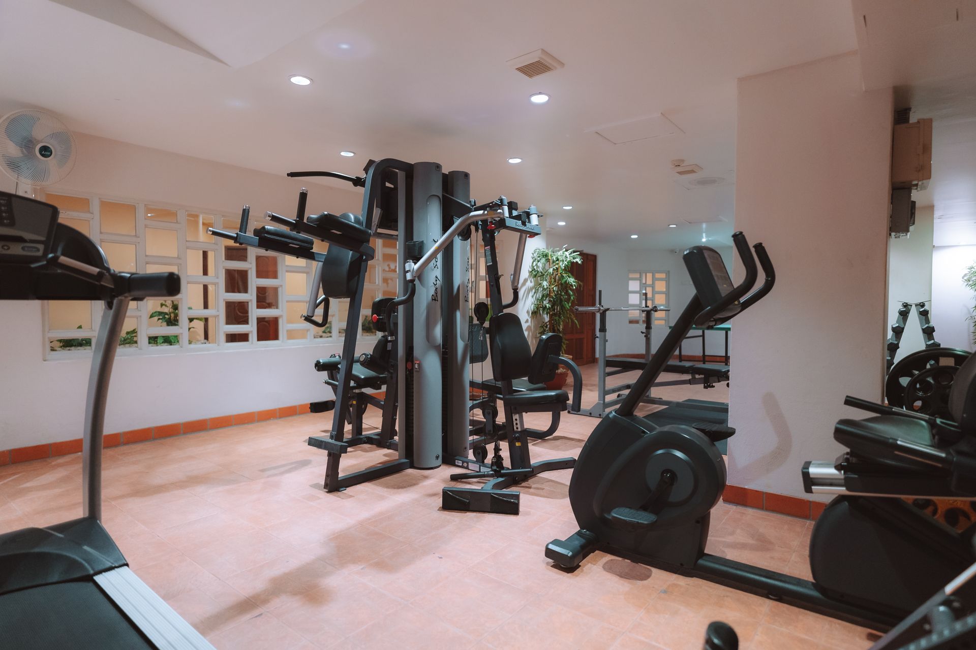 A gym filled with lots of exercise equipment and a treadmill.